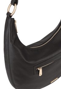 Zwarte leren schoudertas met een gebogen vorm, gouden hardware, een ritsvak aan de voorkant en een gestructureerde afwerking. Beschikt over een ringriem.