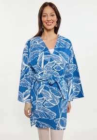 Rivestimento stile kimono blu con motivi a foglia bianchi, maniche lunghe, vita con cintura e fessure laterali, realizzato in un tessuto leggero.