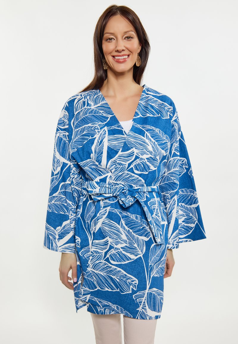 Rivestimento stile kimono blu con motivi a foglia bianchi, maniche lunghe, vita con cintura e fessure laterali, realizzato in un tessuto leggero.
