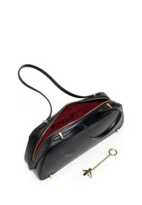Czarna skórzana torba na ramię z złotymi dodatkami i czerwonym wnętrzem. Posiada podwójne zamknięcia na suwak, płaski pasek na ramię oraz brelok.