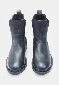 Fekete bőr bokacsizma pár, lekerekített orral és hátul húzófülekkel, fehér háttérrel kiemelve.