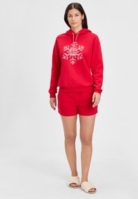 Red hoodie with a white geometric pattern, paired with red shorts. Material appears soft; features a drawstring hood and ribbed cuffs.