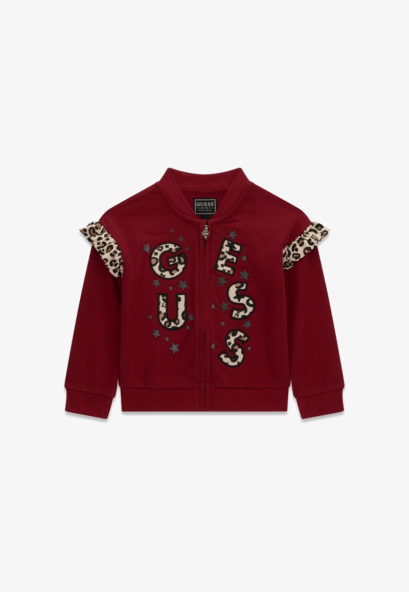Veste zippée marron grenat avec volants imprimés léopard sur les épaules et lettres "GUESS" en motif léopard avec détails étoilés sur le devant.
