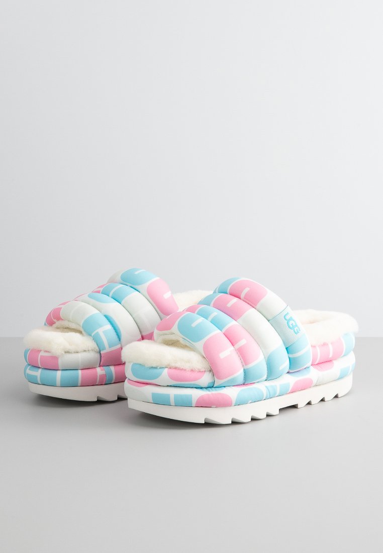 Infradito colorate imbottite con motivi geometrici blu e rosa, morbida fodera in pelliccia sintetica e suola bianca con grip testurizzato.