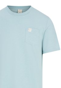 Svetlomodré tričko s krátkym rukávom vyrobené z mäkkej látky, s náprsného vreckom s bielou nálepkou, na ktorej je napísané "PRO TEST". Dizajn s okrúhlym výstrihom.