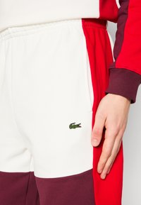 Lacoste ELEVATED COLORBLOCK  - Verryttelyhousut - flour/red-spleen