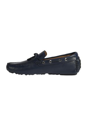 Marineblaue Leder-Mokassins mit Steppdetails, dekorativem Bogen, silbernen Ösen und strukturiertem Gummisohle. Seitenansicht.