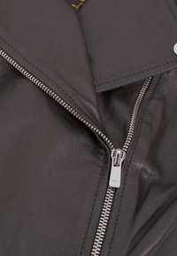 Schwarze Lederjacke mit diagonaler Reißverschlussöffnung, glatter Textur, Metallreißverschluss und einem Reverskragen mit Ziernähten.