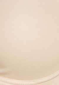 Beige nahtloser Stoff mit glatter Textur, der eine geschwungene Form und eine genähte Kante aufweist. Keine nennenswerten Muster oder Hardware-Details.