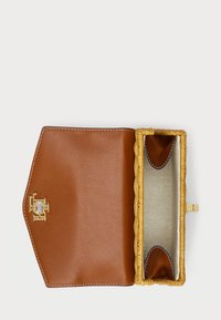 Καφέ δερμάτινο πορτοφόλι με πλεκτή κίτρινη λεπτομέρεια. Το εσωτερικό διαθέτει ομαλή, υφασμάτινη επιφάνεια και χρυσό κούμπωμα για κλείσιμο.