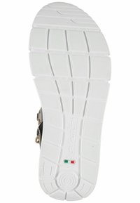 Suola di scarpa in gomma bianca con grip texturizzato, caratterizzata da linee orizzontali e verticali, un logo in rilievo e accenti di colore vicino al tallone.