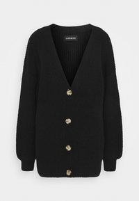 Svart stickad cardigan med lång ärm, djup V-ringning och fem stora beige knappar framtill.
