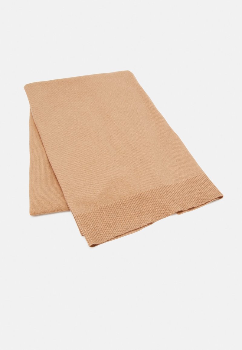 Écharpe tricotée beige à la texture douce, avec un bord côtelé, soigneusement pliée sans motifs ni éléments métalliques visibles.