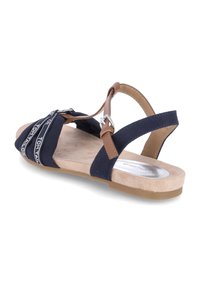 Sandali blu navy con cinturini in pelle marrone, suola beige imbottita e logo decorativo sui nastri in tessuto. Design piatto.