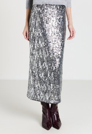 Gonna maxi argento con paillettes, a taglio dritto, texture lucida e motivo sottile, abbinata a stivali in pelle bordeaux al ginocchio.