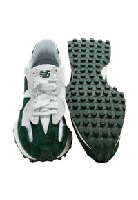 Zapatillas verdes y blancas con un upper de gamuza texturizada, un sistema de cordones prominente y una suela de goma decorada con patrones que presenta agarres circulares elevados.