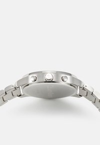 Reloj de acero inoxidable con una caja redonda, que cuenta con una pulsera en tono plateado, dos botones de pulsar y una corona prominente. Superficie lisa y reflectante.