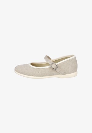 Zapato Mary Jane de lona beige con ribete blanco, suela plana y correa ajustable con hebilla plateada sobre un fondo blanco.