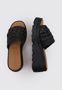 Sandalias deslizantes de tejido negro con una correa estampada, plantilla suave en color beige y suela gruesa negra. Material duradero y silueta elevada.