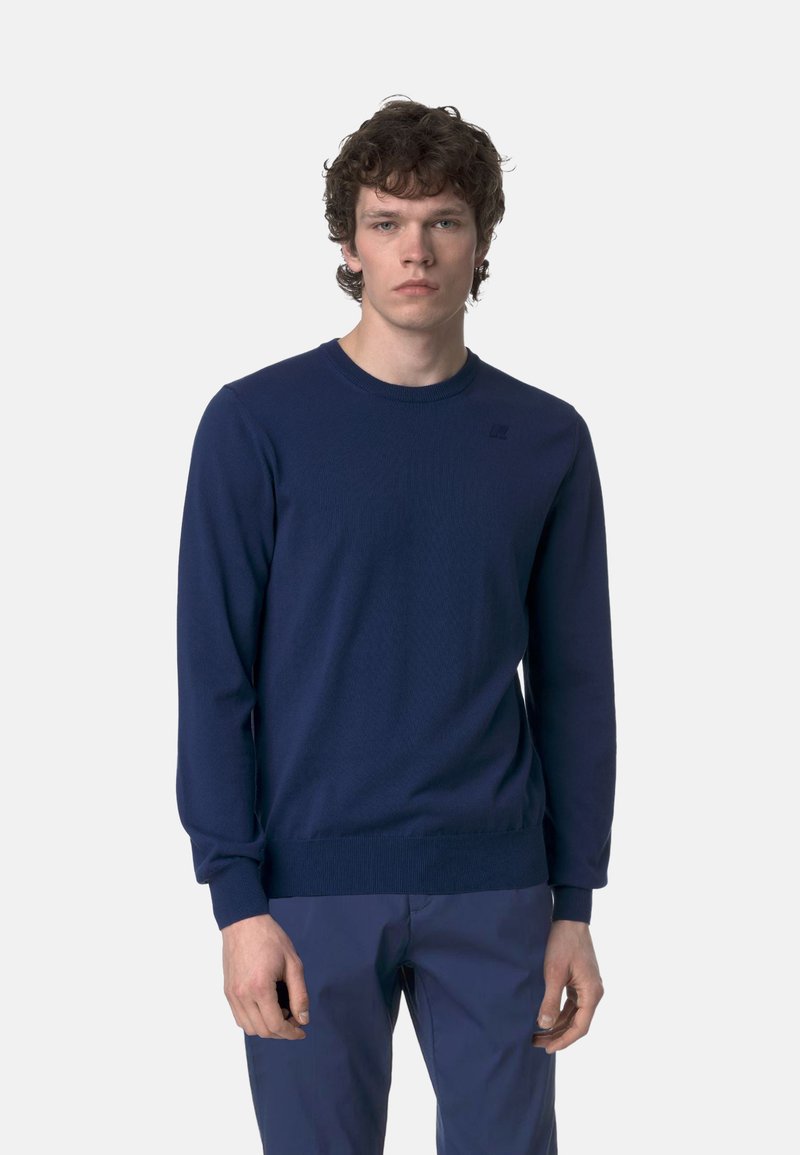 Maglione in maglia blu navy con collo rotondo, maniche lunghe e polsini a costine. Presenta un logo sottile sul petto. Texture morbida, vestibilità normale.