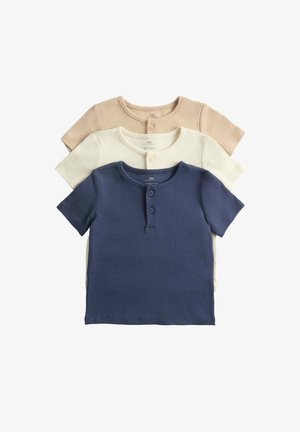 Trzy dziecięce koszulki z krótkim rękawem w kolorach granatowym, ecru i beżowym, każda z dwukolorowym zapięciem na dwa guziki przy dekolcie.
