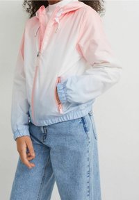 Farveblokeret jakke med en pink og lyseblå gradient, letvægts nylonmateriale, elastiske manchetter og to lynlåslommer.