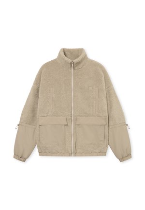 Chaqueta de piel sintética beige con cuello alto, cierre frontal, dos bolsillos en el pecho y dos grandes bolsillos inferiores, con puños elásticos y una textura suave.