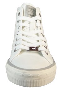 White canvas sneakers with metal eyelets, round toe, textured side panels, and a silver logo tag on the tongue. Rubber sole with star pattern.