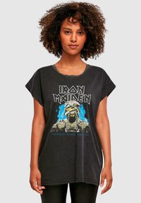 Sort bomulds t-shirt med grafisk tryk af et kranium med kæder og blå lyn, korte ærmer og en afslappet pasform.