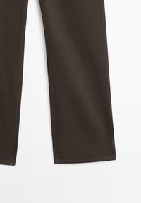Pantalon en coton marron avec jambes droites, coutures visibles et texture lisse. Aucun motif distinct ni détail matériel présent.