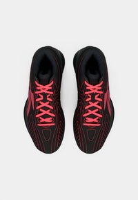 Μαύρα αθλητικά παπούτσια με ροζ κορδόνια και ραφές. Διαθέτουν ανάγλυφη επάνω επιφάνεια και λείο πάτο, σχεδιασμένα με αθλητική σιλουέτα.