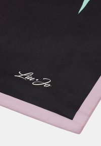Černý šátek se světle růžovým okrajem, s hladkým povrchem a bílým tištěným logem. Design obsahuje jednoduchý, elegantní vzor.