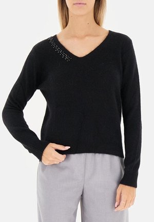 Maglione nero a maglia con scollo a V, maniche lunghe e una leggera texture a coste. Presenta decorazioni lungo il collo.