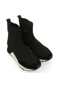 Bottines noires avec un dessus en tricot texturé, semelle blanche contrastante et poignées à l'arrière. Design mince et épuré avec des bouts ronds.