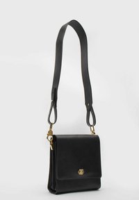 Czarna skórzana torba na ramię o prostokątnym kształcie, z pojedynczym zapięciem na klapę, złotymi akcentami i regulowanym paskiem.