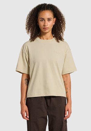 T-shirt oversize beige clair en coton doux, avec un col rond et des manches courtes. Détail de broderie subtile à l'avant.