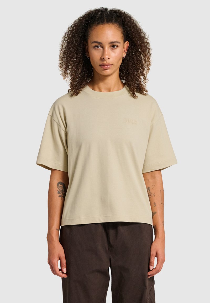 Lichtbeige oversized t-shirt gemaakt van zachte katoen, met een ronde halslijn en korte mouwen. Subtiele borduurdetails aan de voorkant.