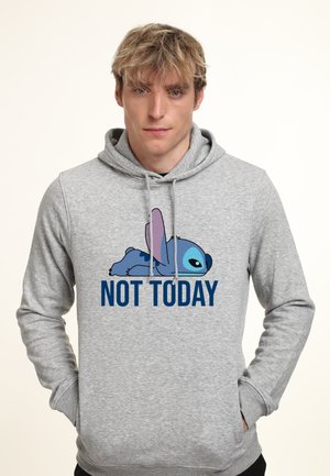 Ung mand iført en grå hættetrøje med en blå tegneseriefigur, der ligger ned, og teksten "IKKE I DAG" på forsiden.