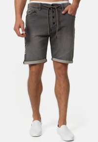 Graue Jeansshorts mit umgeschlagenen Säumen, ausgestattet mit einem Kordelzug und einem Knopfverschluss. Seitentaschen und dekorative Nähte.