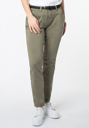 Olive green cotton blend pants with a slim fit, featuring side pockets and a braided black belt. Worn with white platform sneakers.