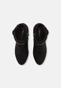 Musta mokka nilkkurit, joissa on pyöreä kärki, cuff-yksityiskohta ja säädettävä solki sivussa. Koko merkattuna 37 sisällä.