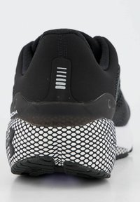 Scarpa sportiva nera con un motivo a rete sulla suola e una tomaia in tessuto testurizzato. Presenta un tallone imbottito e accenti orizzontali.