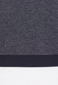 Felpa blu navy con tessuto texturizzato, dotata di orlo a costine. Il design complessivo è semplice, senza motivi o dettagli visibili.