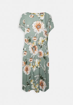 Robe vert clair longueur genou avec manches courtes, motif floral orange et blanc, et ceinture nouée à la taille.