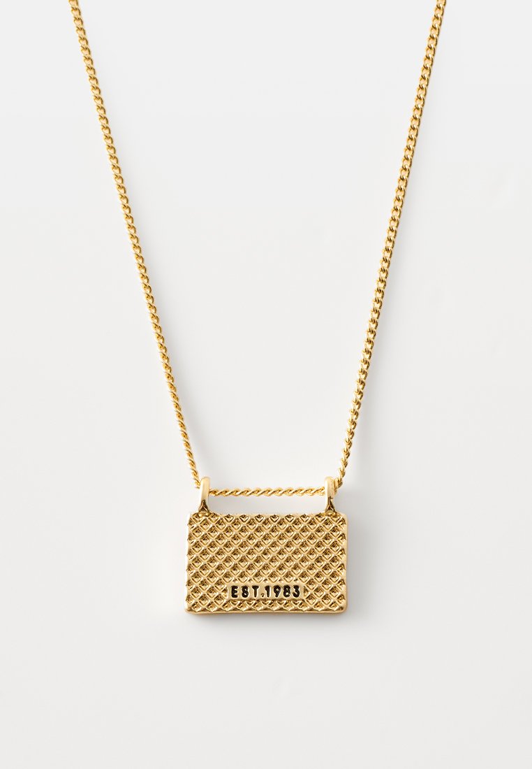 Goldfarbene Halskette mit einem strukturierten rechteckigen Anhänger im Diamantmuster und der Gravur "EST. 1983", der an einer verdrehten Kette hängt.