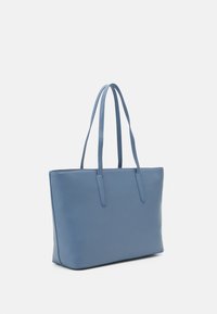 Blå strukturerad totebag i slätt, texturerat material. Har två långa handtag och ingen synlig hårdvara eller dekorationer.