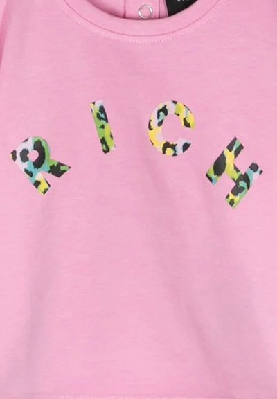 T-shirt in cotone rosa con lettere in grassetto che spellano "RICH" in un motivo leopardato multicolore. Collo rotondo con un piccolo strappo sul retro.
