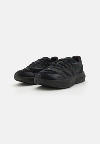 Black athletic shoes featuring a mix of mesh and suede materials, textured rubber sole, and prominent lace detailing for secure fit.
