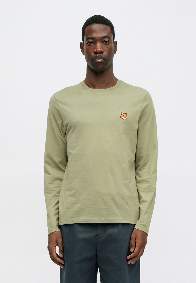 Long-sleeve shirt in olive green cotton, featuring a small embroidered fox head on the left chest and a classic round neckline.