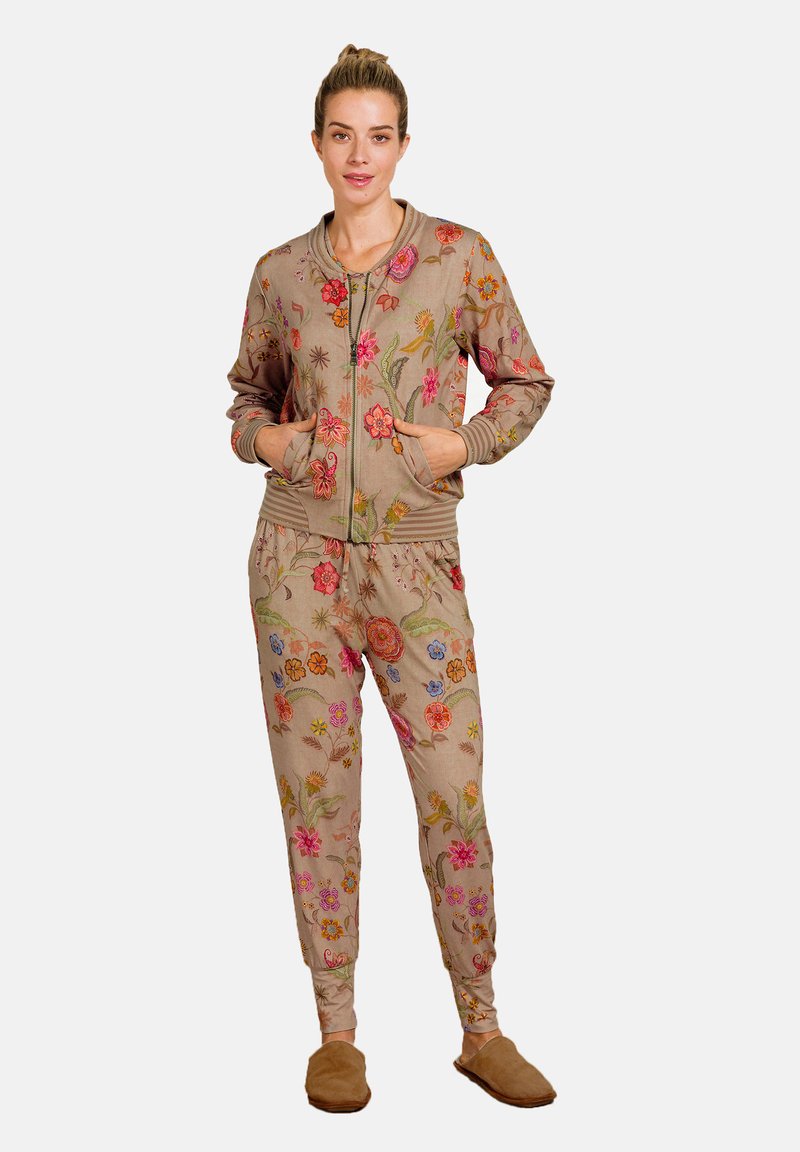 Beige loungewear set met bloemenborduurwerk, bestaande uit een ritssluiting jack met geribde manchetten en bijpassende broek met elastische tailleband. Zachte stof.